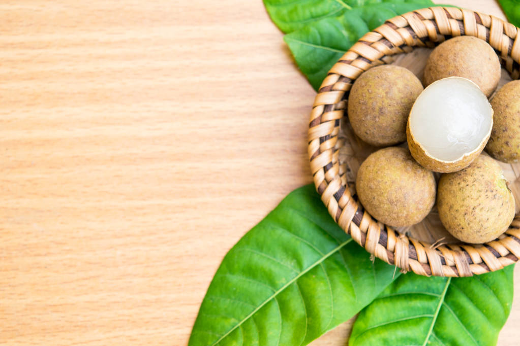 鲜龙眼龙眼叶木桌上设置图片