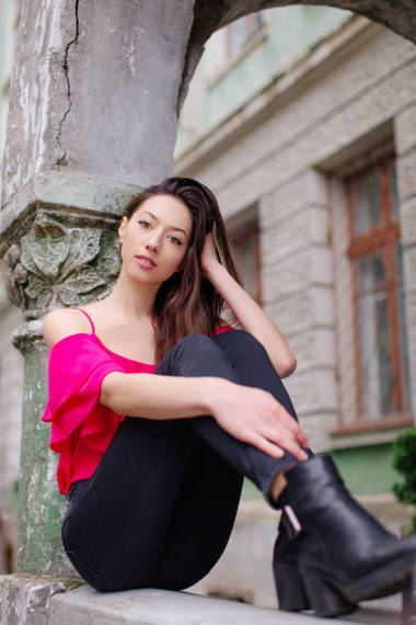 女孩坐在公园的长凳上，看看相机