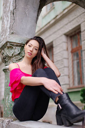 女孩坐在公园的长凳上，看看相机