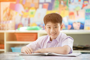 快樂的亞洲孩子讀書和看相機(jī)