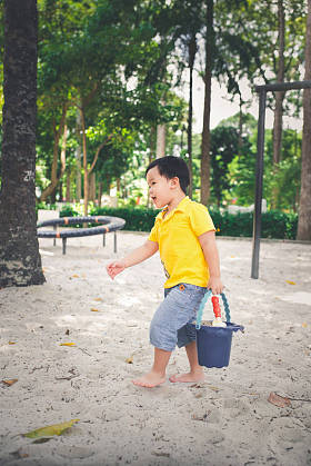 男孩玩斗和沙子 