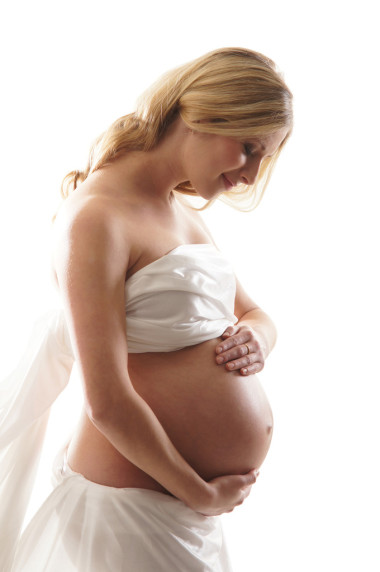 年輕有魅力的懷孕女人上白色隔離