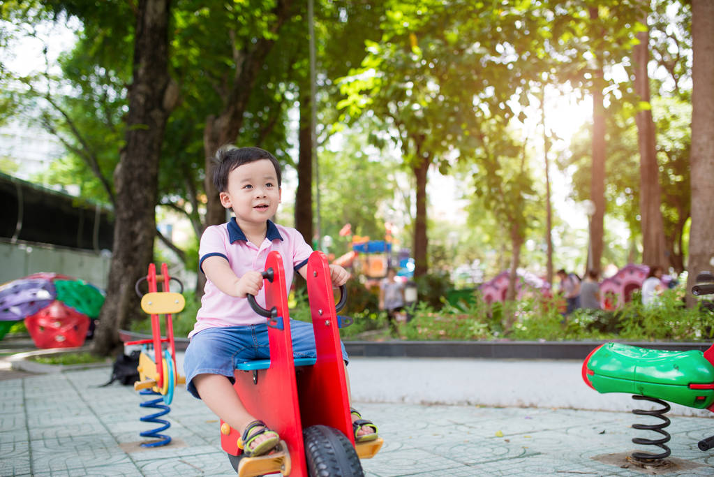活跃的小男孩玩跷跷板 活跃的小男孩玩跷跷板