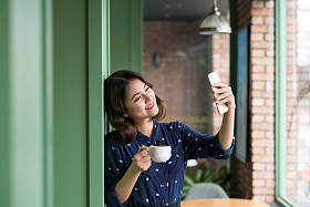 女人拿着杯子和以自拍照图片
