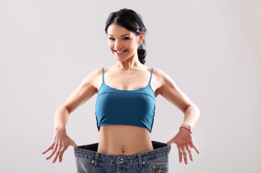 可愛的苗條女孩減肥后穿舊牛仔褲
