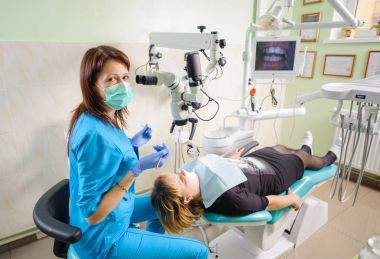 女牙醫(yī)工作用顯微鏡在現(xiàn)代牙醫(yī)診