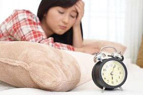 睡眼惺忪的女子与闹钟