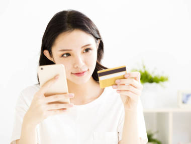 女人買在線信用卡與智能手機(jī)圖片