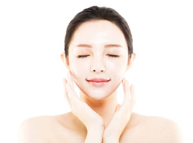 特寫年輕美麗的女人臉上白色孤立