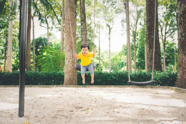 男孩在操場(chǎng)上蕩秋千圖片