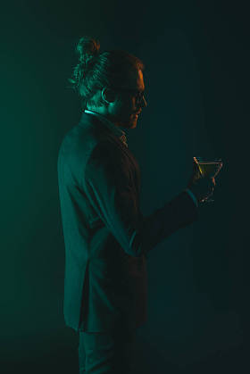 男人拿着玻璃与鸡尾酒礼服图片