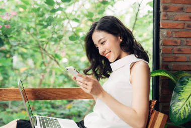 亚洲女人在电话上打字图片