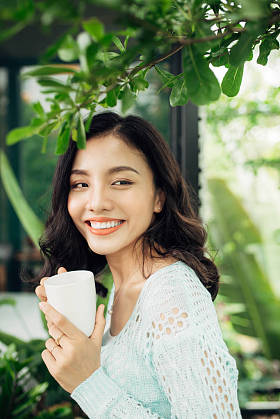 年轻的亚裔女子和杯子图片