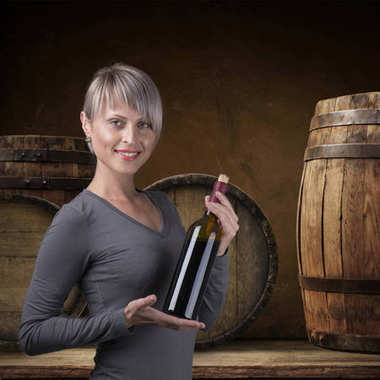 年轻的赤脚女孩与一瓶酒的草篮缓缴自然背景 年轻的赤脚女孩与一瓶酒的草篮缓缴自然背景