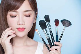 化妆刷子的美丽女人 