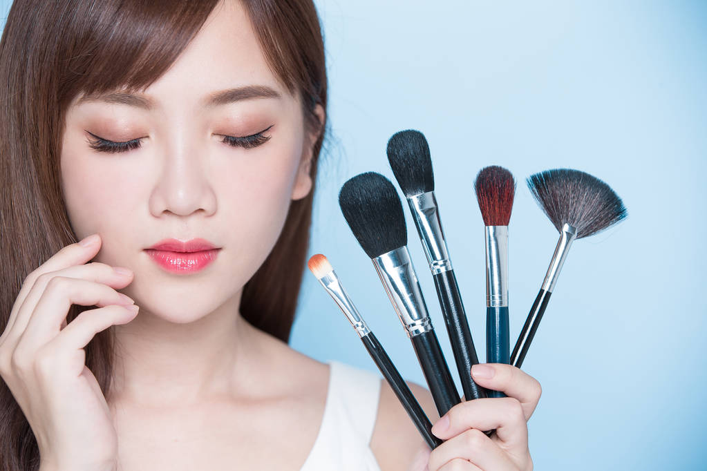 化妆刷子的美丽女人 