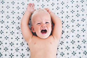 生气的小男孩躺在床上哭