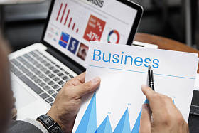 指向在纸页上的西装的男人图片