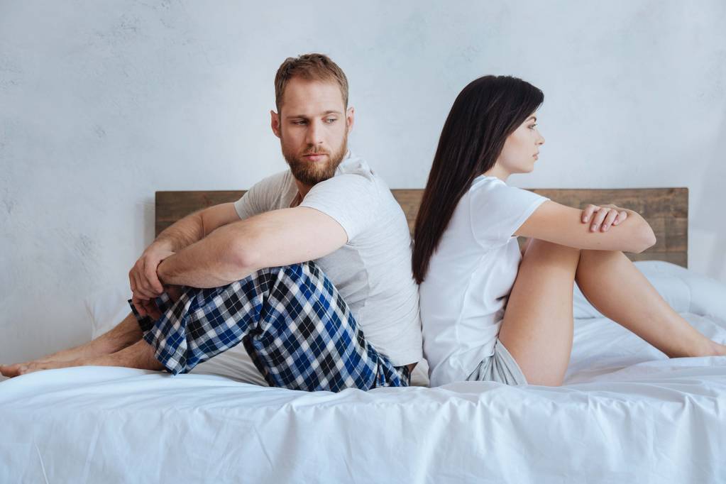 坐在床上的冲突严重夫妇 坐在床上的冲突严重夫妇