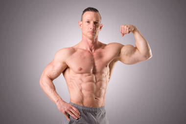 適合肌肉喬裝孤立在灰色的背景上