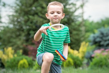 可愛(ài)的男孩玩一個(gè)游戲扔在夏天公園戶外響