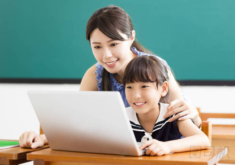 年輕的老師幫助孩子與計算機課