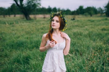 在绿色草地上的红发女士