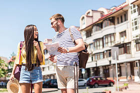 多民族对夫妇的游客与地图图片