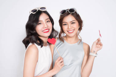 兩個女孩拿著紙做的愛心