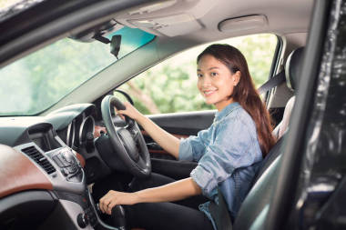 美麗的亞洲女人微笑著享受駕駛一輛汽車和漢