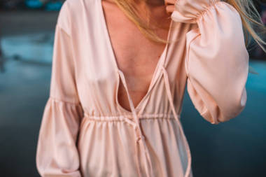 金發(fā)女孩穿著粉紅色的連衣裙在日落，印度尼西亞，巴厘島的海灘上