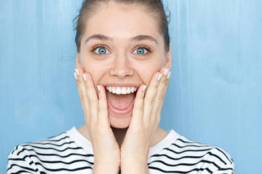 關(guān)閉了畫像的女性，哦我的上帝，哇情感表達。驚喜的微笑年輕女孩竊聽的藍眼睛，手牽得廣泛地張大了嘴巴驚訝的臉上