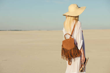 独自旅行。走在沙漠中的沙上的女人