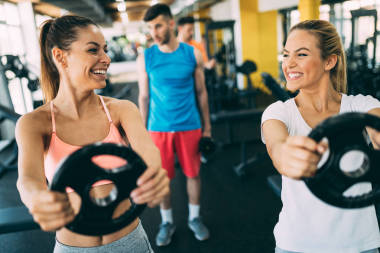 漂亮的女人在一起工作在健身房