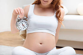 怀孕的女人控股闹钟图片