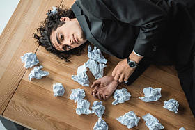 躺在办公室的桌子上的商人