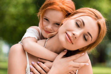 母親和女兒擁抱在公園照片