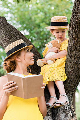 母亲和女儿在公园里读书照片