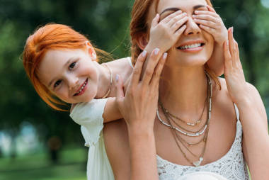 閉上眼睛的母親在公園里的女孩