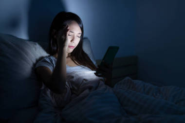 女人感覺眼痛和使用手機