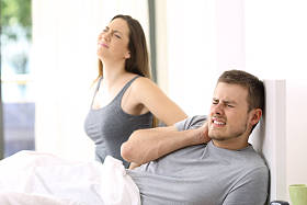 痛苦的夫妇痛在不舒适的床上