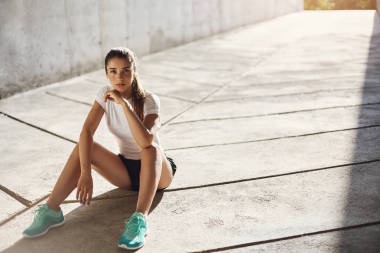 自信、 健康的女子赛跑运动员准备开始看着镜头微笑她日常马拉松。城市体育概念