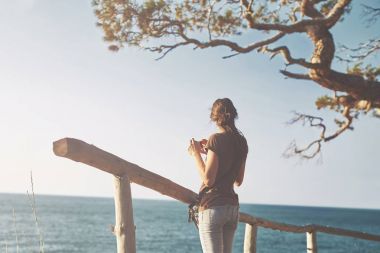 幸福的女人，在海滩上智能手机拍张照片