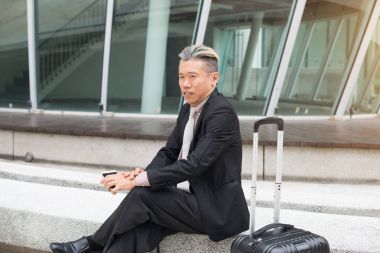 男人坐在一起的手提箱照片