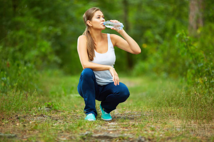  木材的女人喝水 