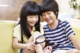 亚洲儿童玩放大镜