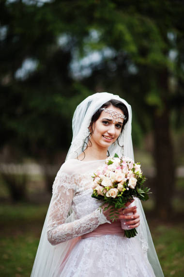 可爱的新娘，在公园与一束构成上的肖像