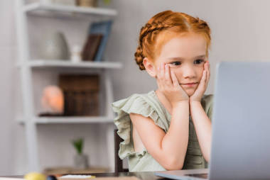 小女孩在看著筆記本電腦圖片