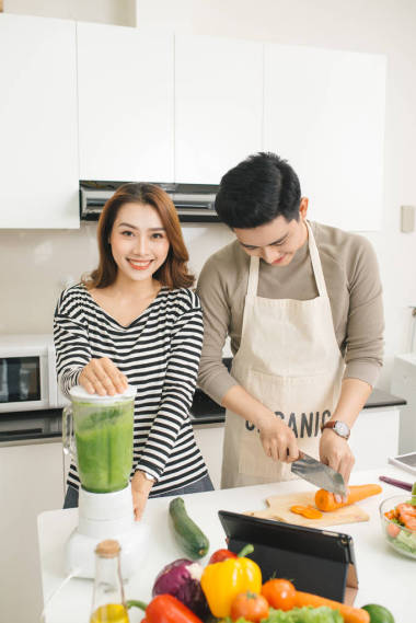 亞洲的夫妻情人在家里的廚房做飯，在一起