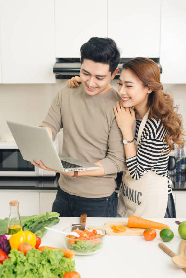 夫婦用筆記本電腦找一些食譜圖片
